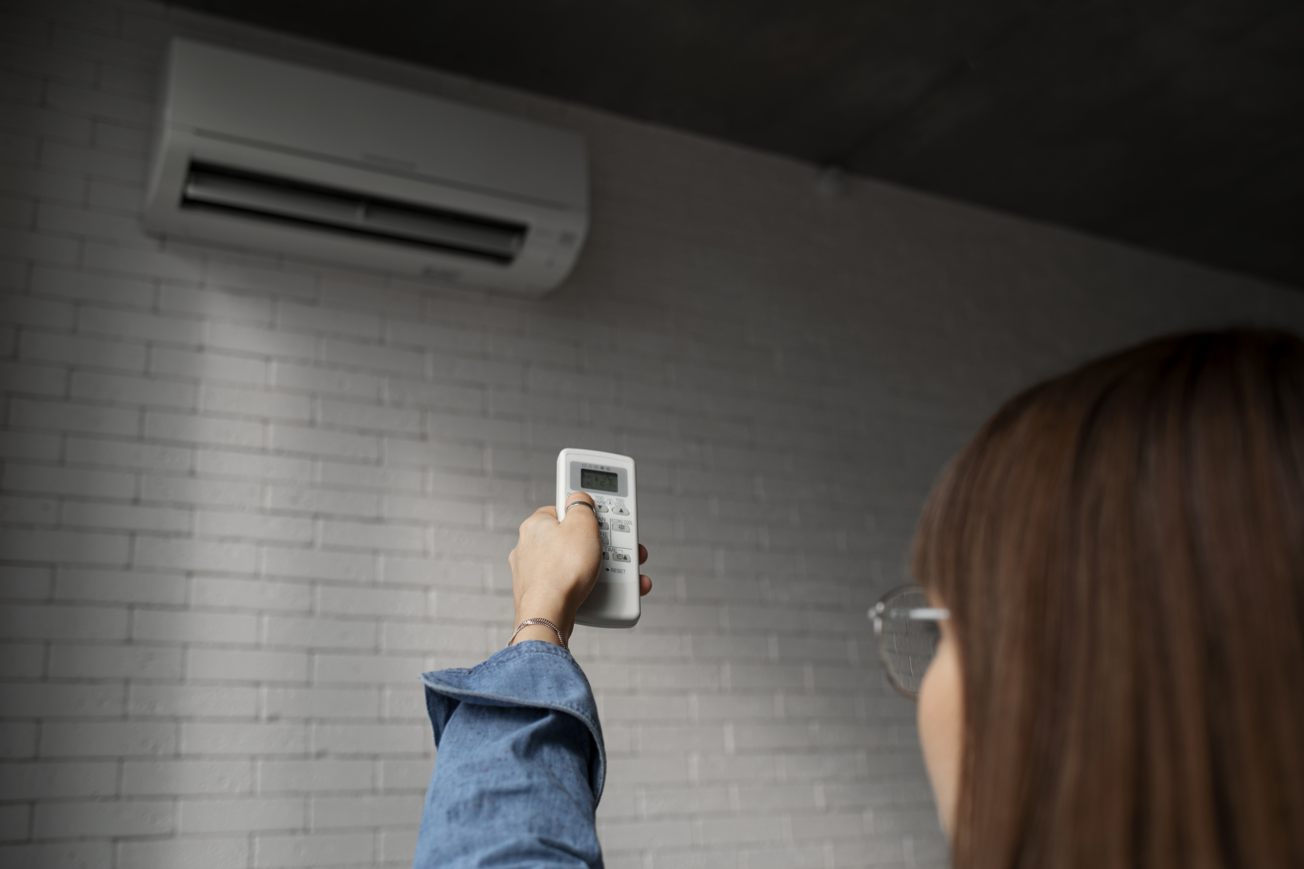 Woman holding AC remote